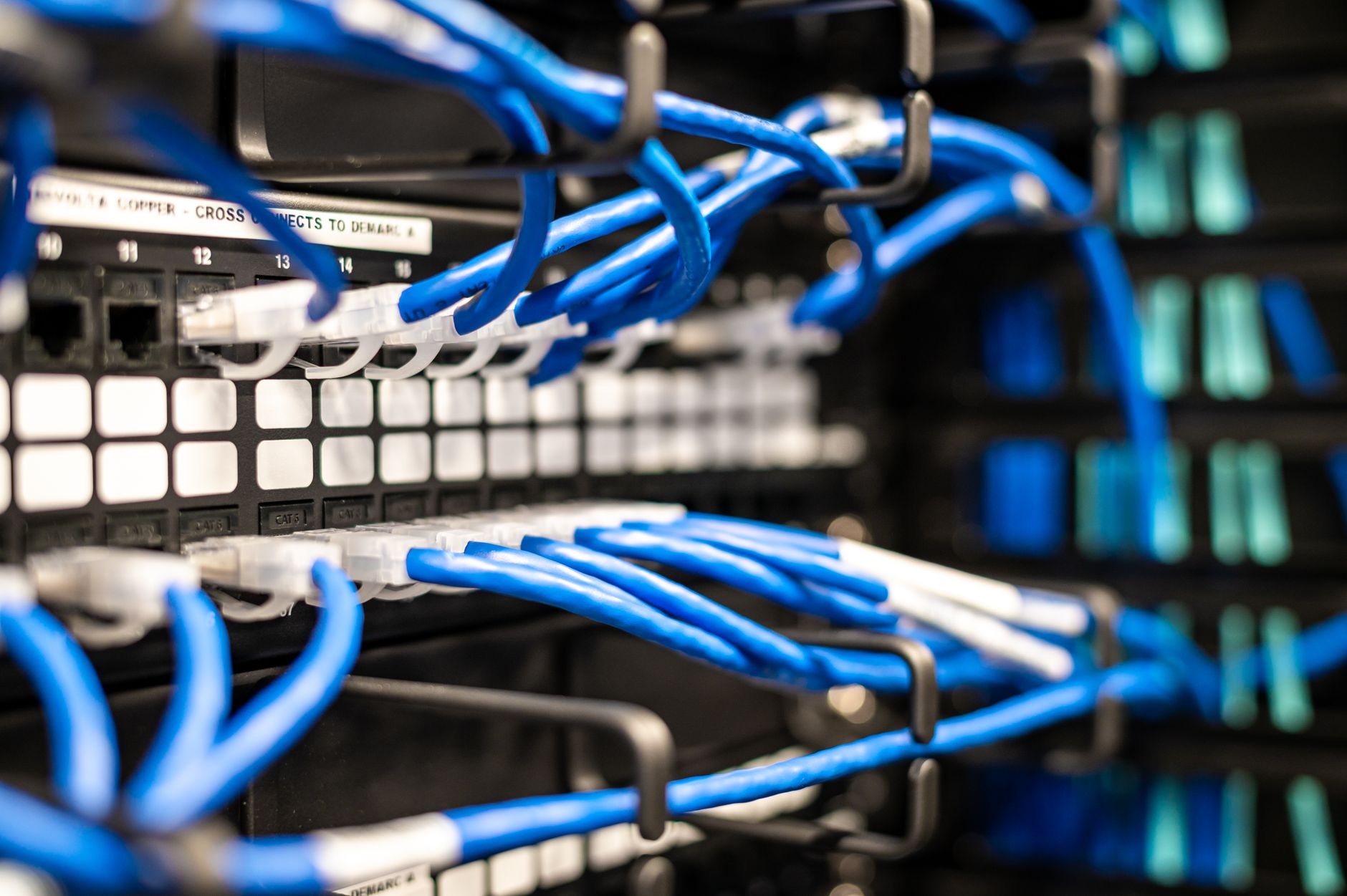 Dark server room with blue lights and cables